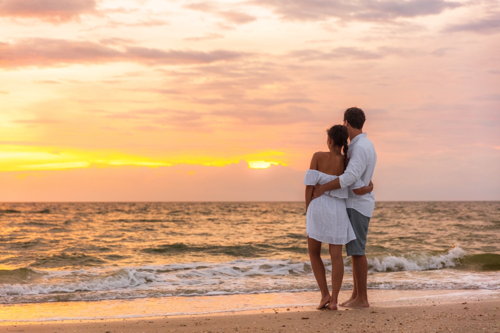 A couple enjoying the sunset on our private beach at the most romantic hotel in Florida on Flagler Beach.